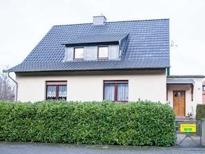 A two-story house with a sloped roof, a small attic window, and a front door with a sign indicating 'free' accommodation. - Apartment Sandra Mattaj (Blankenburg (Harz))