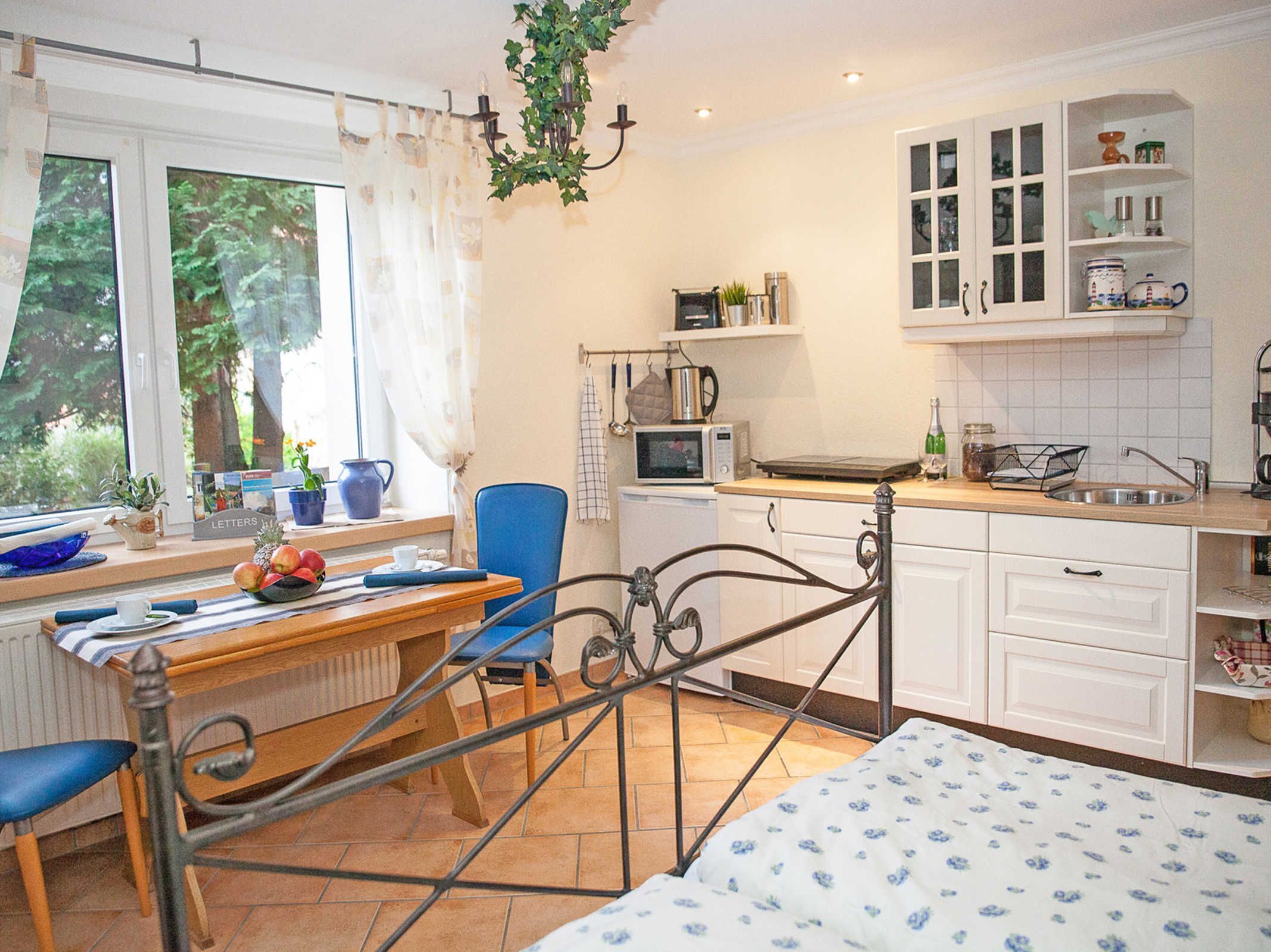 Une chambre confortable avec un lit, une table de chevet, une chaise et une fenêtre avec des rideaux.