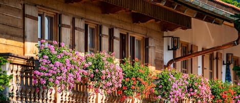 A wooden building with a balcony adorned with flowering plants.