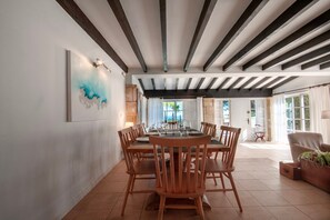 Ein Essbereich mit einem runden Tisch, Holzstühlen und einem modernen Deckenstil.