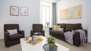 A modern living room with two brown sofas, a white coffee table with breakfast items, and abstract art on the walls. - Singular Stays Mar44 VII (Valencia)