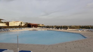 Una piscina amb gandules i una torre de socorristes.