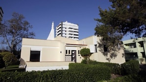 Un edifici modern amb teulada plana i una torre central.