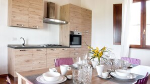 Eine moderne Küche mit Holzausstattung, einer Edelstahl-Dunstabzugshaube und einem eingebauten Backofen.