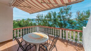 A balcony with a table and chairs, overlooking a scenic view of trees and a body of water. - Beautiful apartment in Kustici with WiFi (Kustici)