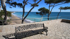 A bench overlooking a beach with a clear view of the ocean and trees. - Estudio 7 (Miami Playa)