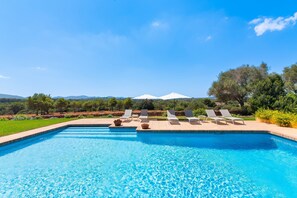 A swimming pool with lounge chairs and a view of the landscape.
