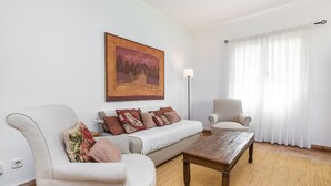 Een woonkamer met een bank, fauteuil en salontafel.