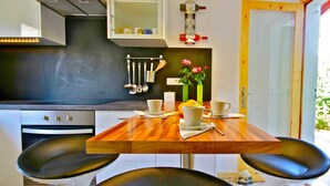 Una cocina compacta con una mesa de comedor, sillas y horno empotrado.
