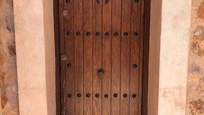 A wooden door with a metal handle and a circular metal plate in the center. - CASA PIEDRA MALLORCA (Son Ferrer)
