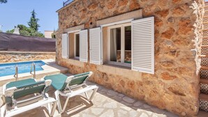 A stone building with a pool and two lounge chairs. - CASA PIEDRA MALLORCA (Son Ferrer)