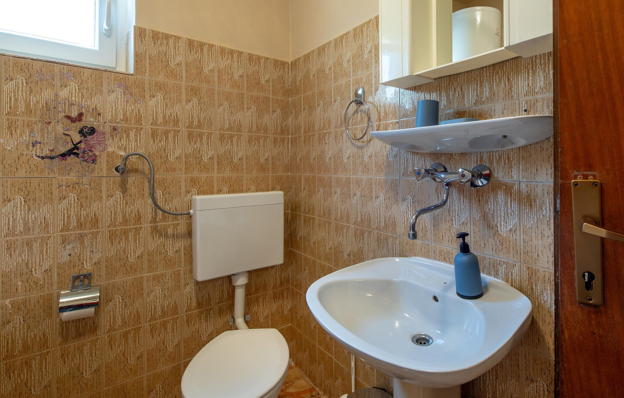 A bathroom with a toilet, sink, and shower.