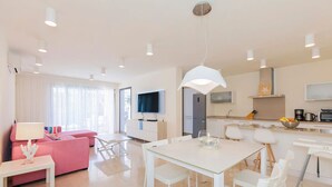 Eine moderne Wohnung mit Essbereich, Küche und Wohnzimmer.
