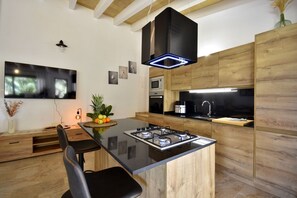 A modern kitchen with a central island, built-in appliances, and wooden cabinetry. - 785879 Ses cases - 785879 Ses Cases (Manacor)