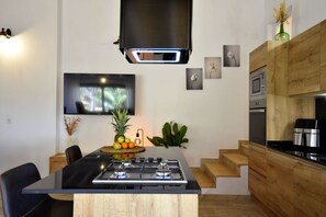 Eine moderne Küche mit Gaskochfeld, Flachbildfernseher und Holzschränken.