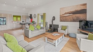 A modern living room with a grey sofa, a wooden coffee table, and a television.