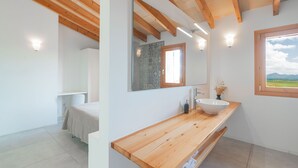 Ein modernes Badezimmer mit einem Holzkosmetikschrank, einem großen Spiegel und Blick ins Freie.