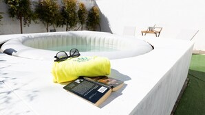 A hot tub with a yellow towel and a book on a white platform. - Villetta Myalea - Capilungo (Capilungo)
