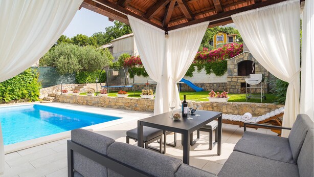 A covered outdoor area with a pool, seating, and a stone building in the background. - Nice apartment in Srinjine (Srinjine)