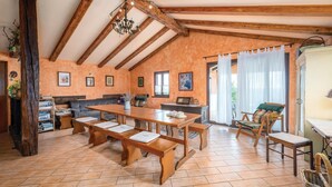 Un'area pranzo rustica con panche di legno, un tavolo e un lampadario.