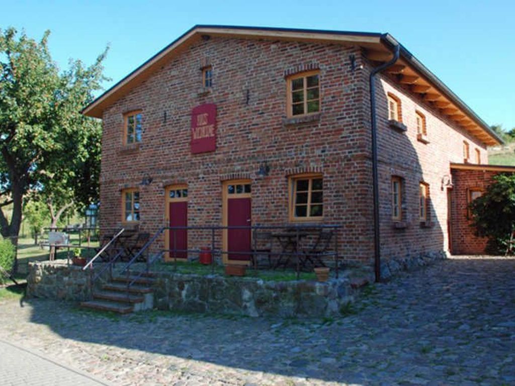 A brick building with a red door and a sign that reads 'Hotel.'