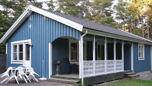 A blue wooden house with a porch, a small deck, and outdoor seating. - 3 bedroom stunning home in Slite (Slite)