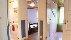 A hallway leading to a bedroom with a bed, a bathroom with a sink, and a staircase. - 3 bedroom stunning home in Slite (Slite)