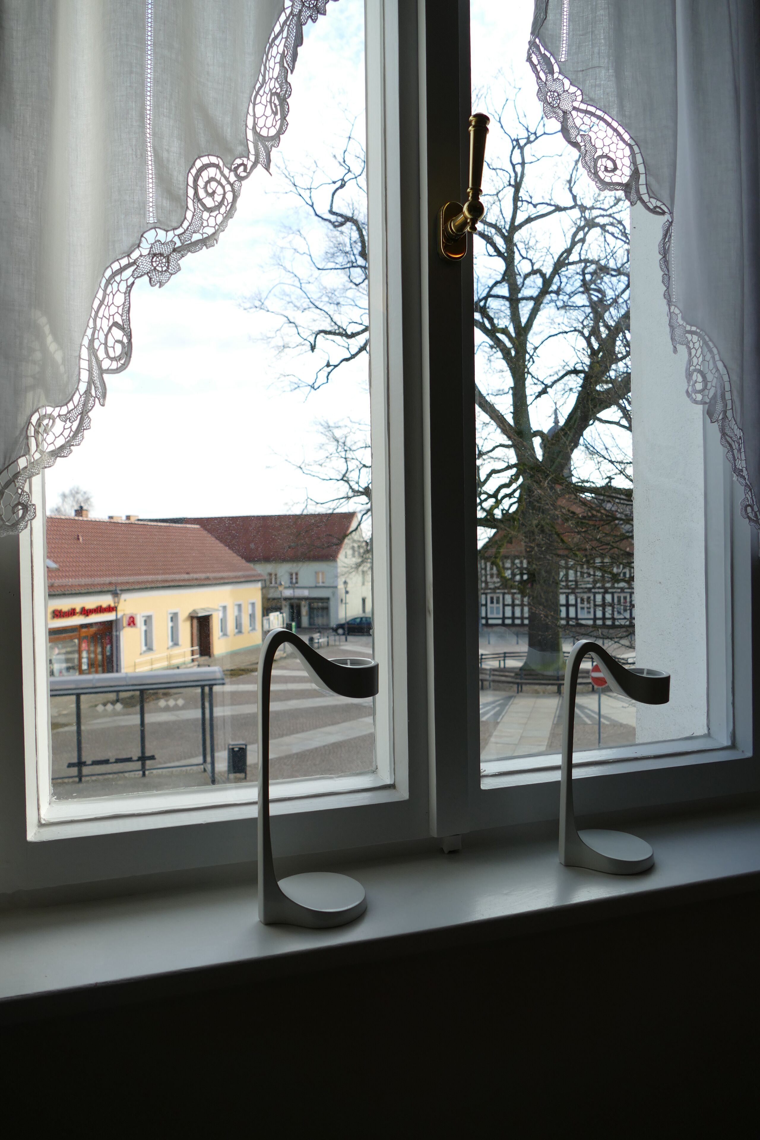 Ein Fenster mit Blick auf ein Gebäude und einen Baum.
