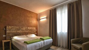 Una moderna camera d'albergo con un letto grande, un tavolino, un divano e una finestra con tende.