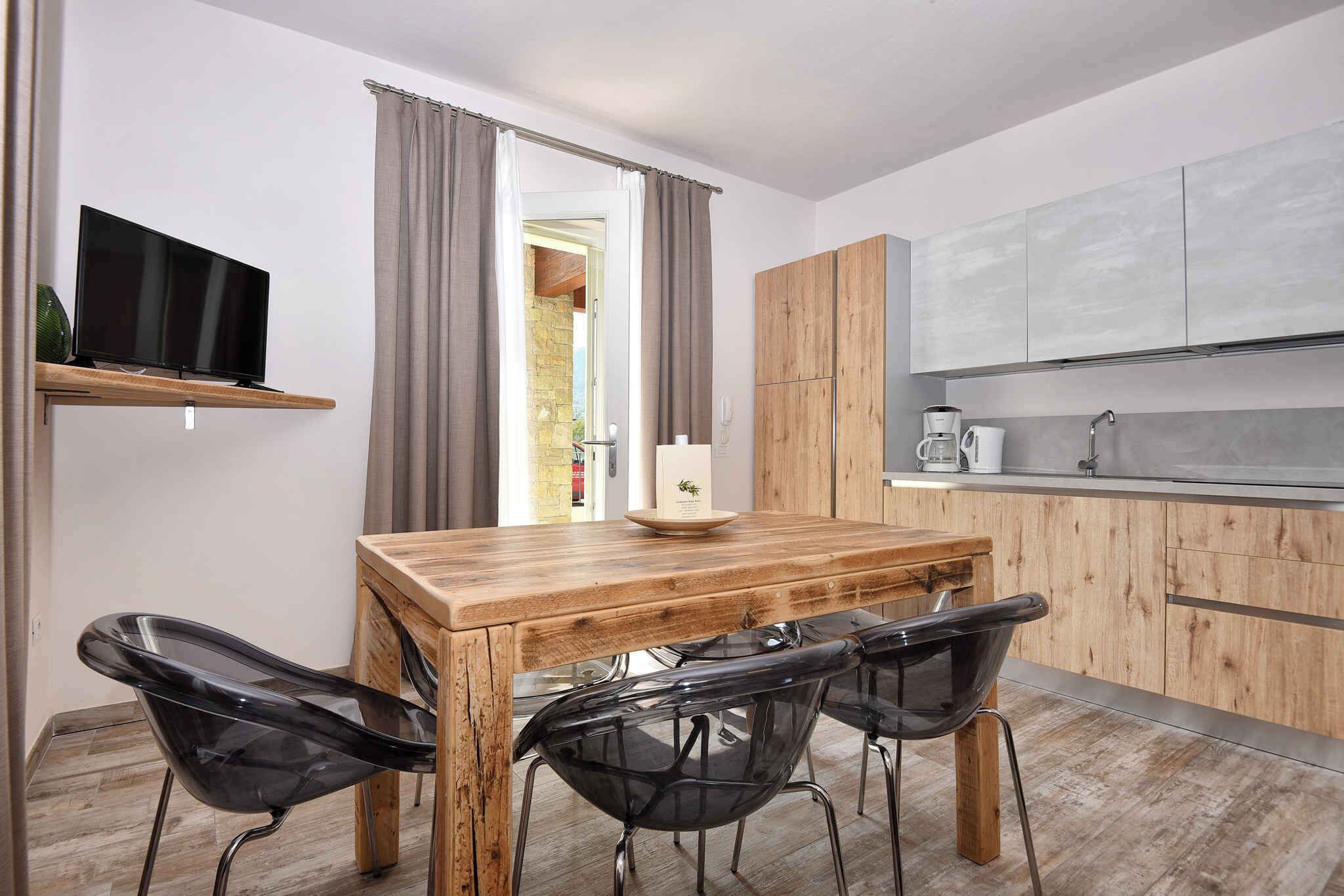 A modern kitchen with wooden cabinets, a built-in oven, and a coffee maker.