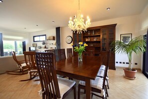 Ein Esszimmer mit Holztisch, Stühlen, einer Pendelleuchte und einem Blumentopf.