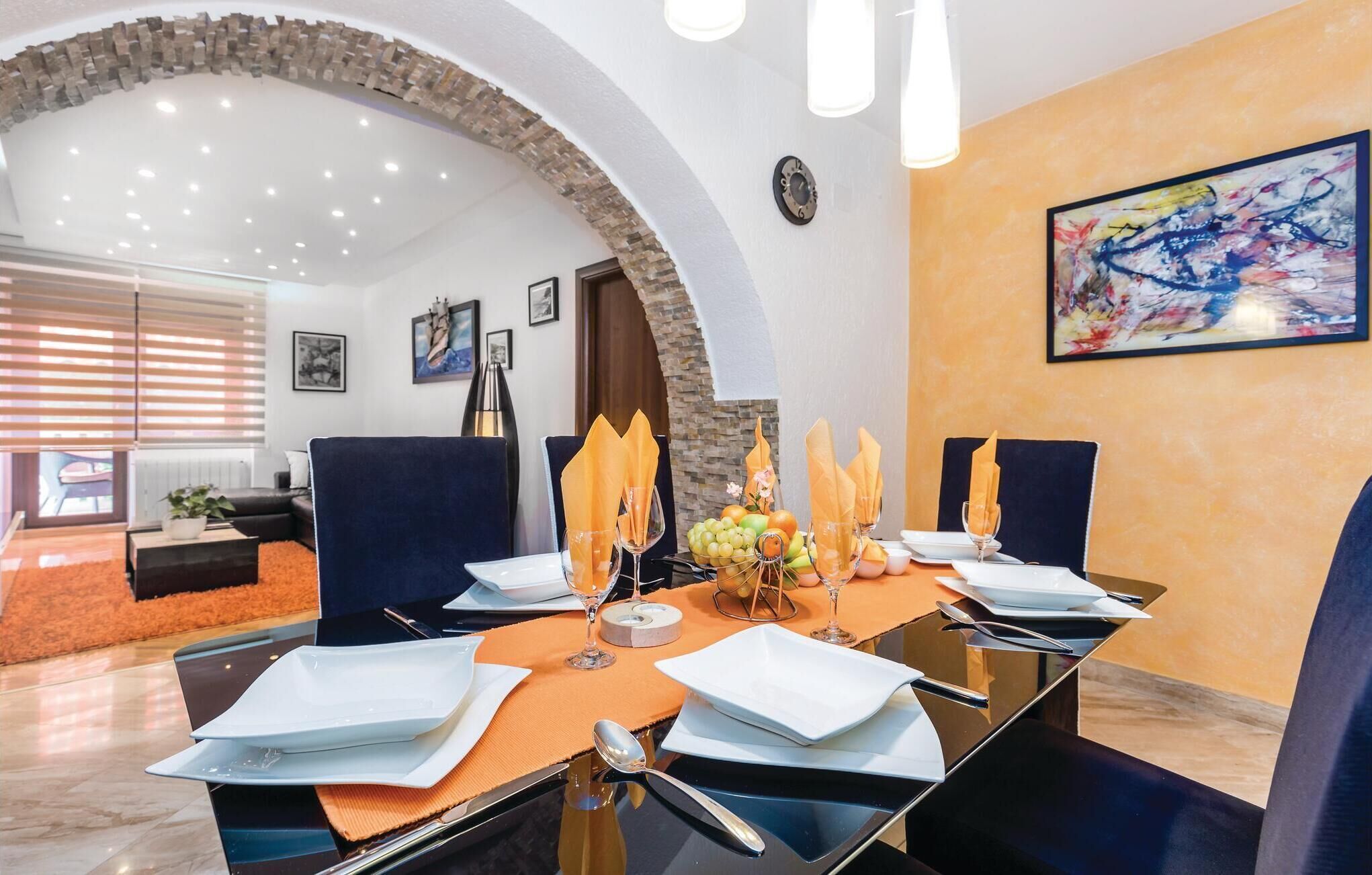 A modern conference room with a glass table, blue chairs, and a stone archway.