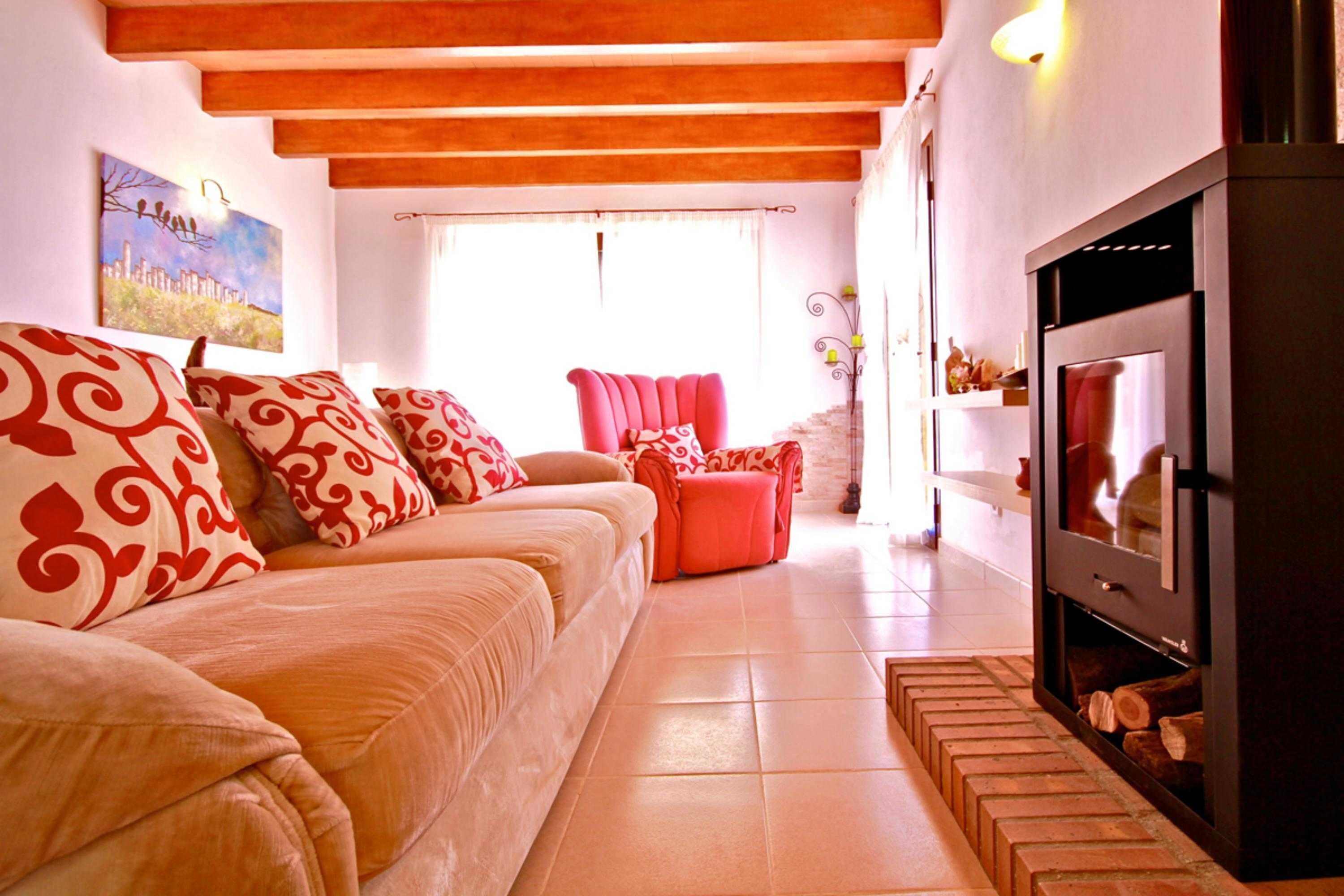 A living room with a sofa, red armchair, and a fireplace.