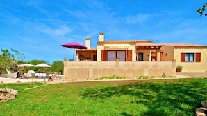 Une maison à deux étages avec un balcon, une piscine et un jardin.