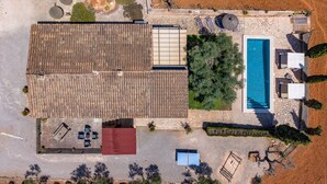 Vue aérienne d’une propriété dotée d’une piscine, d’un espace salon extérieur et d’un patio couvert.