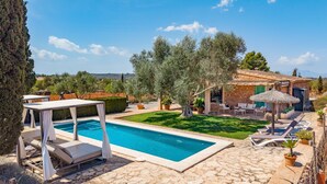 Un espace piscine avec des chaises longues et une terrasse en pierre.