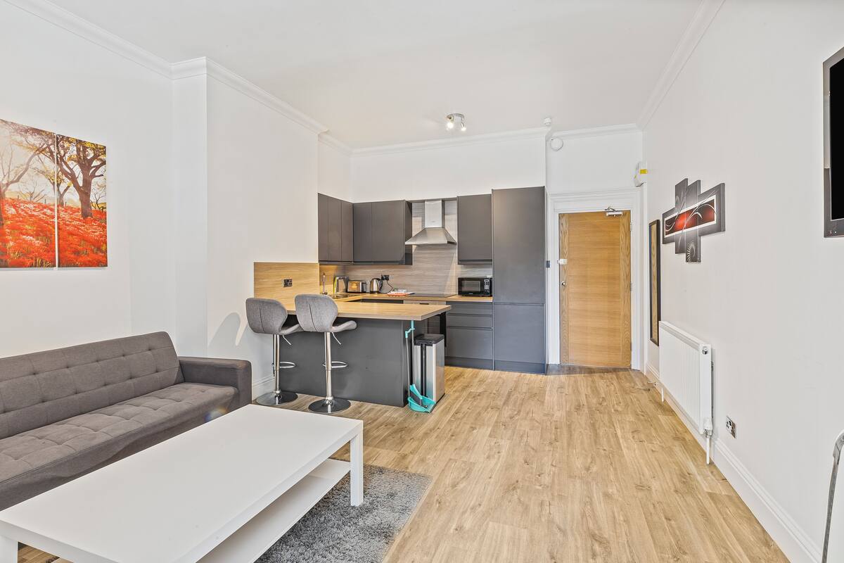 A modern apartment with a living area, kitchen, and dining space.