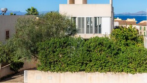 Un edificio moderno con techo plano, ventanas grandes y vista al mar.