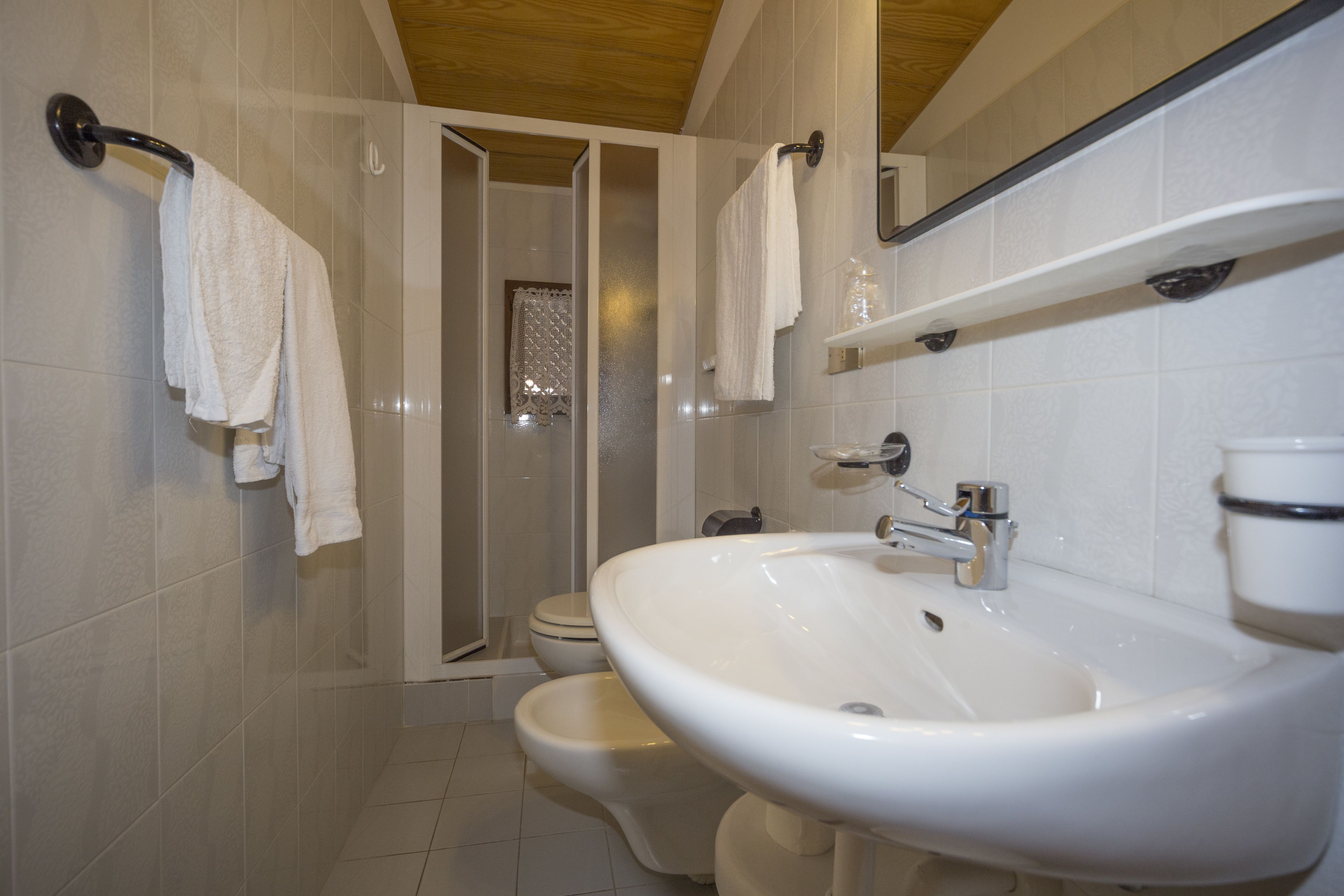 Une salle de bain équipée d’une douche, de toilettes, d’un bidet et d’un lavabo.