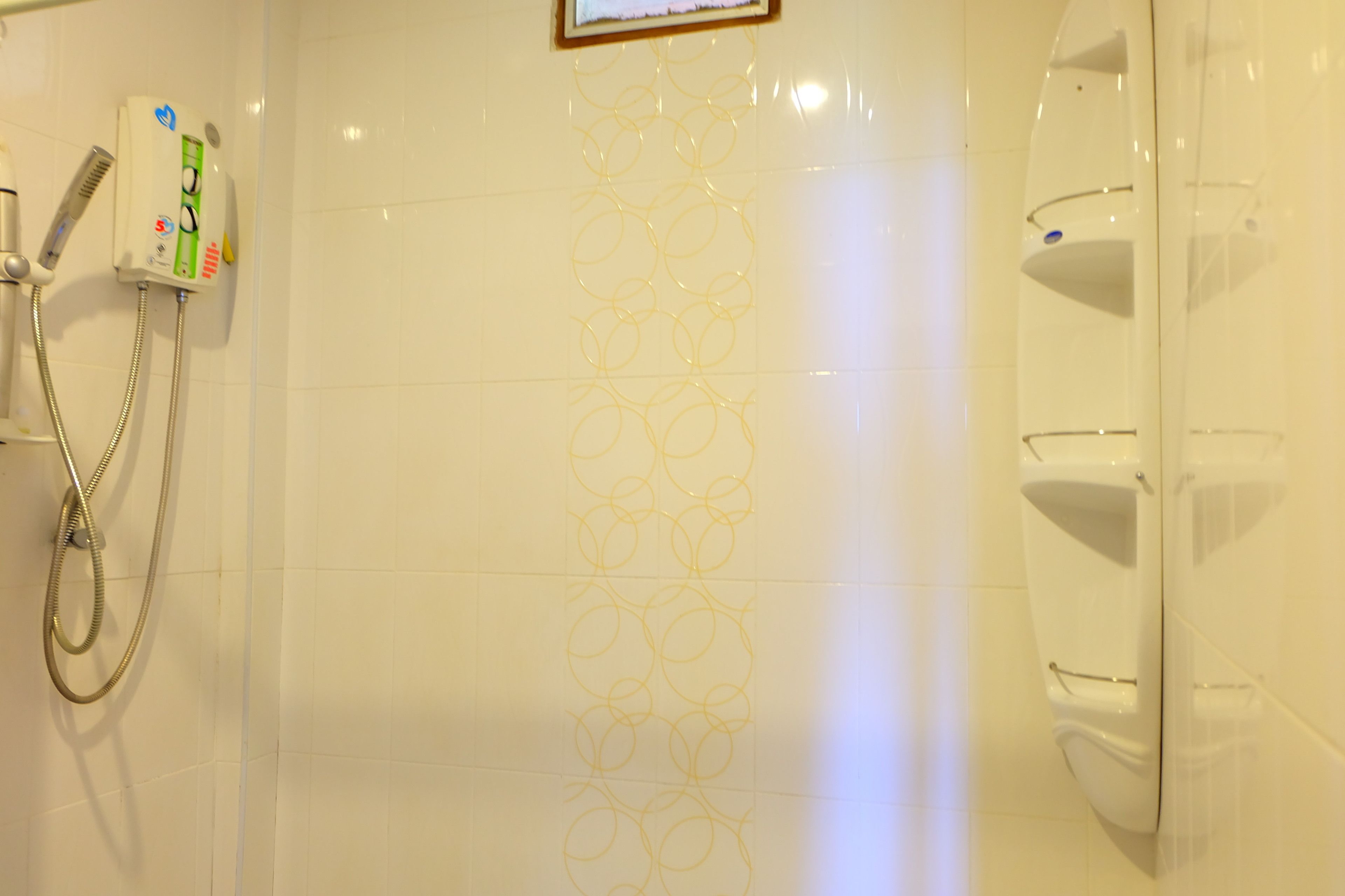 Un baño con ducha, inodoro y secamanos.