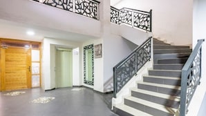 A staircase with black railings, a wooden door, and a green door.