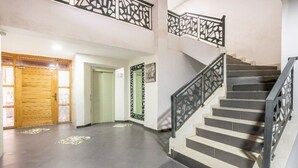A staircase with a black metal railing and a wooden door at the bottom. - Appartement 15 ensoleillé à 5 min de la plage El Jadida (El Jadida)