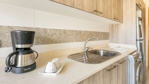 A kitchen with a coffee maker, sink, and washing machine. - Appartement 15 ensoleillé à 5 min de la plage El Jadida (El Jadida)