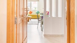 A hallway with a wooden door, white walls, and a tiled floor. - Appartement 15 ensoleillé à 5 min de la plage El Jadida (El Jadida)