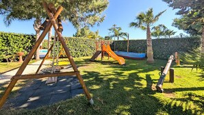A playground with a swing set, slide, and climbing structure. - Beautiful apartment in Marsala -TP- with outdoor swimming pool (Marsala -TP-)
