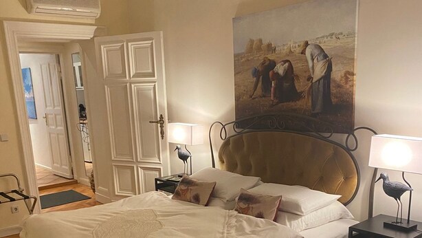 A bedroom with a bed, bedside tables, a clock, and a painting on the wall. - Super * * * apartment at the main station with internet, washing machine (Berlin)