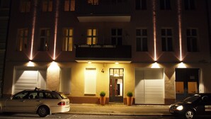 A multi-story building with a ground-level entrance, two potted plants, and a car parked in front. - Super * * * apartment at the main station with internet, washing machine (Berlin)