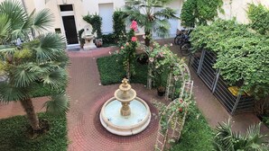 A courtyard with a central fountain, surrounded by palm trees and potted plants. - Super * * * apartment at the main station with internet, washing machine (Berlin)