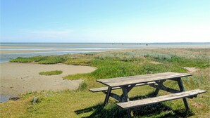 A picnic table in a grassy area with a view of the beach and ocean. - Amazing home in ørsted with kitchen (Ørsted)