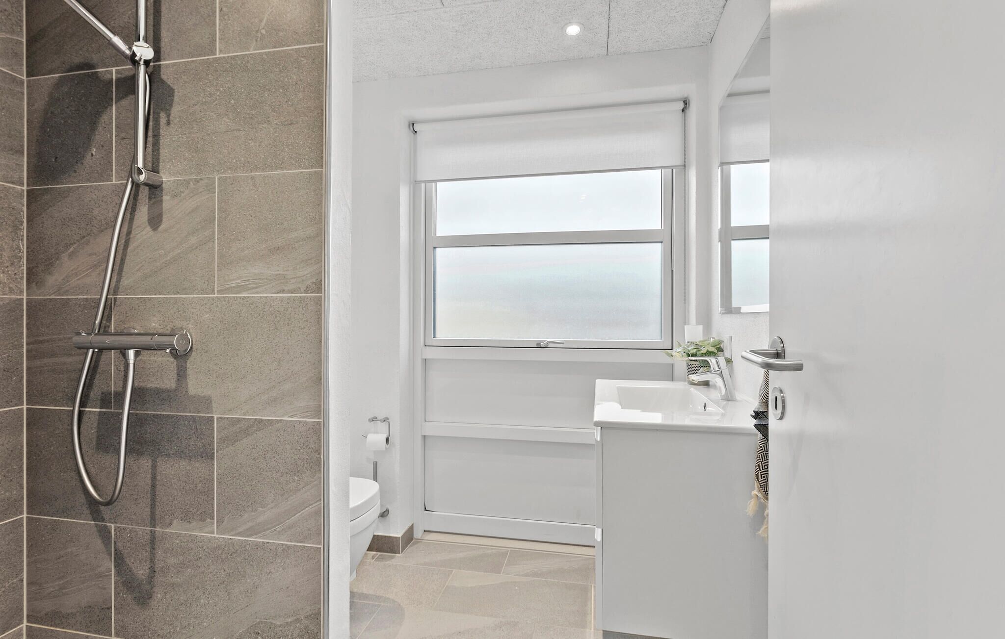 Un baño moderno con ducha, inodoro y lavabo.